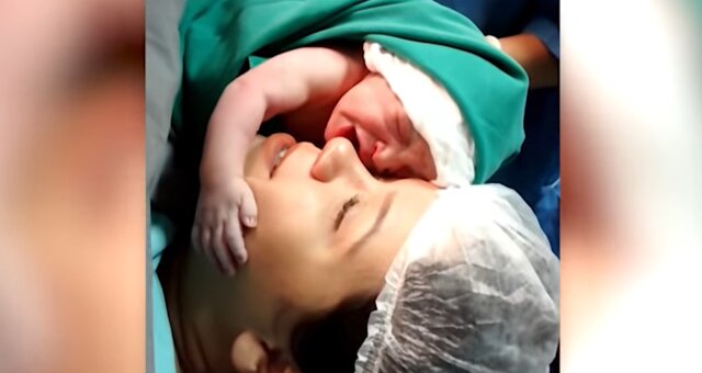 Neugeborenes Baby umarmt seine Mutter. Quelle: Screenshot Youtube